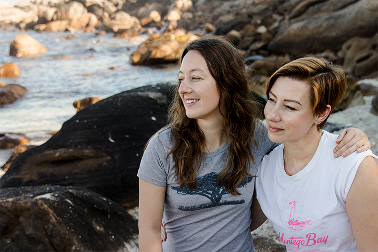 Money Magnet founders, Alex and Anna sitting on a beach in Cape Town to promote their course that covers topics on women and finance within South Africa.
